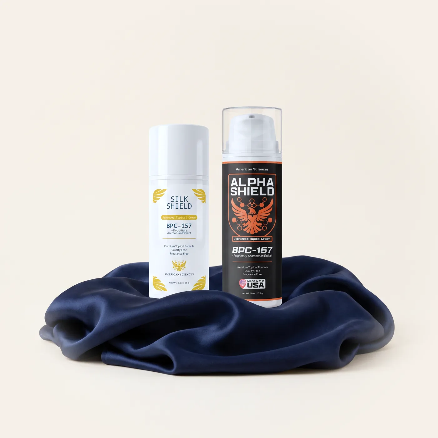 Cream Bundle — Silk Shield and Alpha Shield standing together on a pool of navy silk